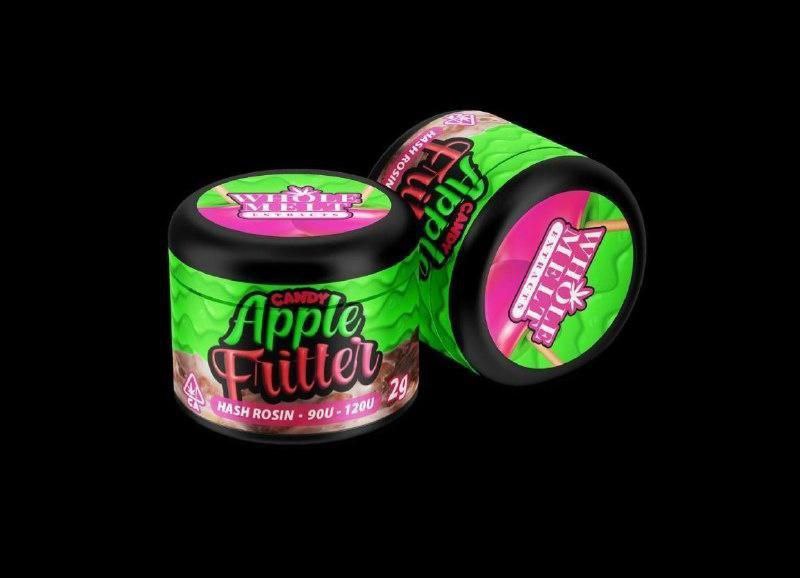 Two containers of "Import placeholder for 38" hash rosin are displayed against a black background. The containers are green with pink and black labeling, prominently featuring the product name "Import placeholder for 38" and indicating 2 grams of content.