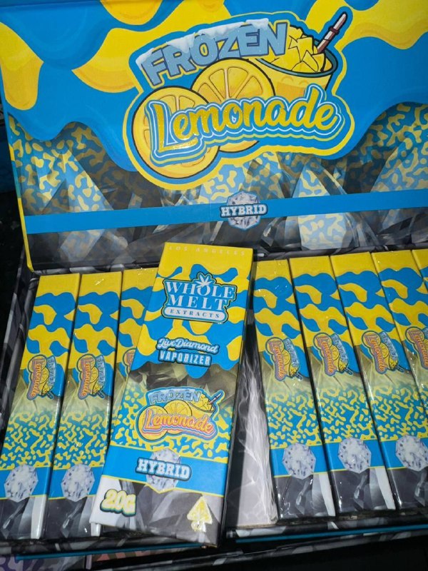 A colorful display box labeled "Import placeholder for 62" containing multiple vape cartridges. The blue and yellow packaging features a lemon, ice, and camouflage patterns, with the phrase "Whole Melt Extracts" and "Hybrid" written on the box.