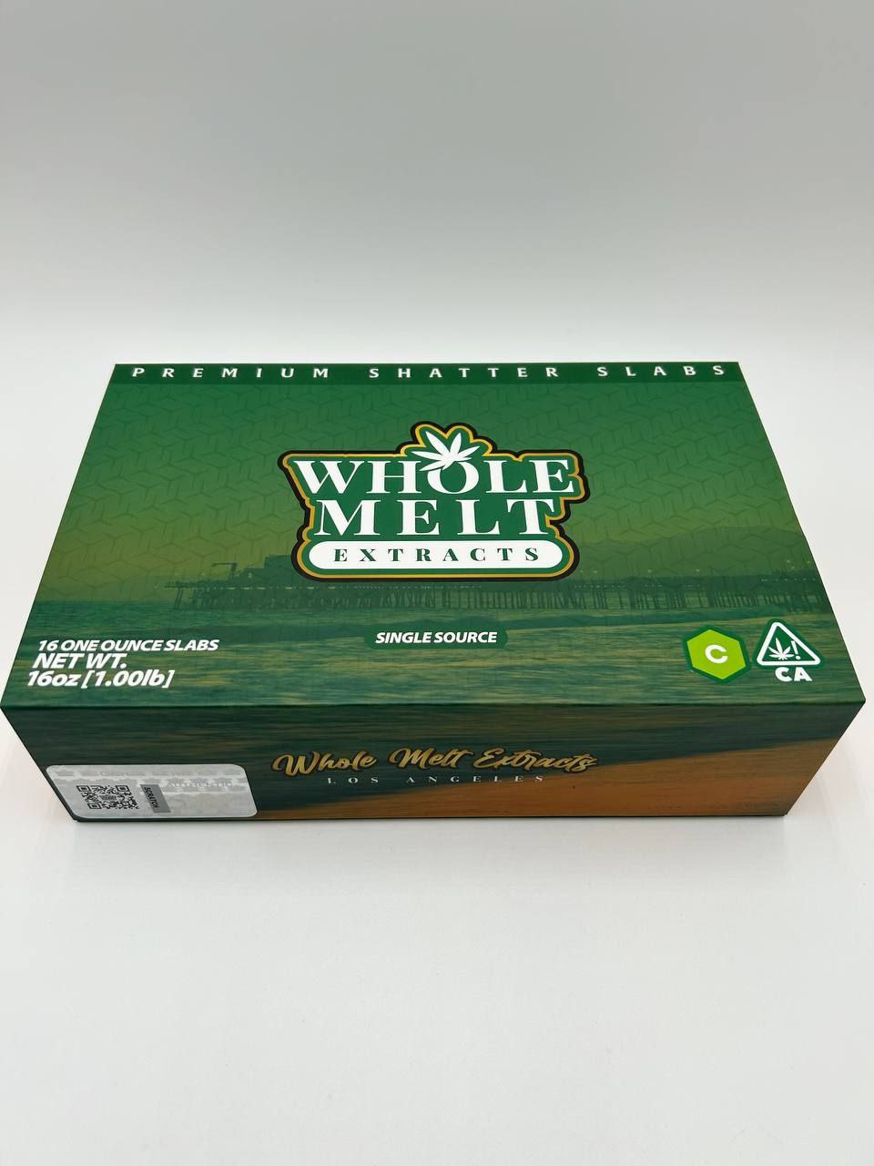 A packaged box of "Import placeholder for 45" labeled as "Premium Shatter Slabs." The box is colored green and gold with the brand's logo prominently displayed. The text on the box indicates a net weight of 16 ounces (1 pound).