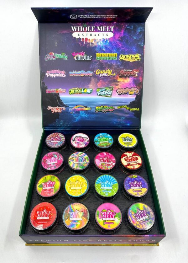 Open box displaying brightly colored packaged products, each labeled with different flavors such as "Guava", "Banana", and "Candy Cane". The background features vibrant, galaxy-themed artwork and the words "Whole Melt Exotic Edition".
