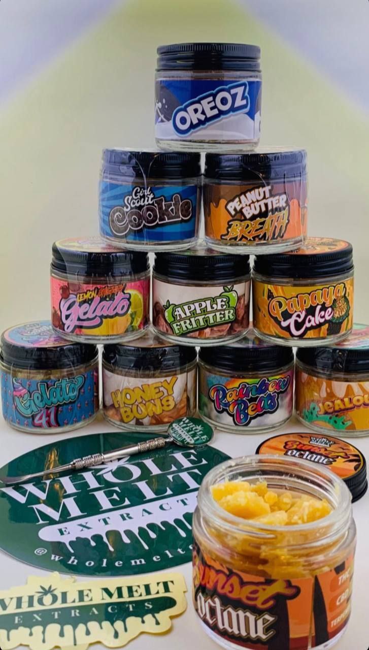 A variety of Import placeholder for 17 jars are stacked in a pyramid shape, each labeled with different strain names such as Oreoz, Gelato, and Apple Fritter. A few branded stickers are placed in front of the jars.