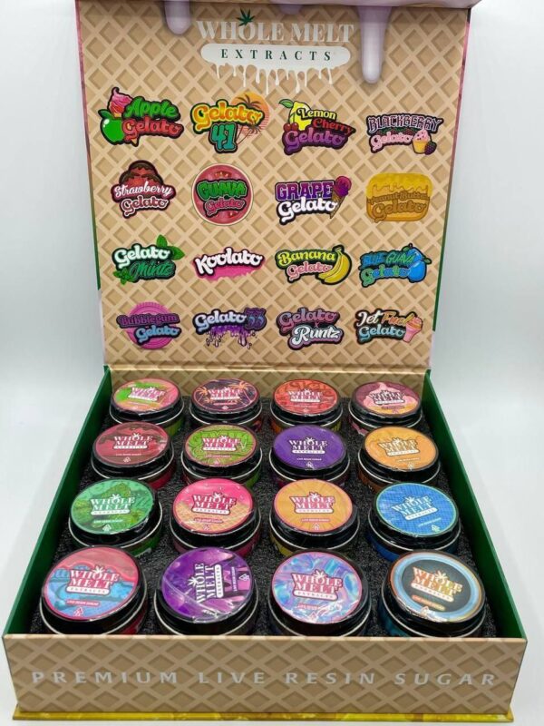 An open display box shows 18 jars of variously flavored live resin sugar from Whole Melt Extracts Wholesale. The top lid features a list of the available flavors, including Apple Gelato, Gelato 41, Kiwi Gelato, Runtz, Banana Runtz, and more, each with colorful labels.