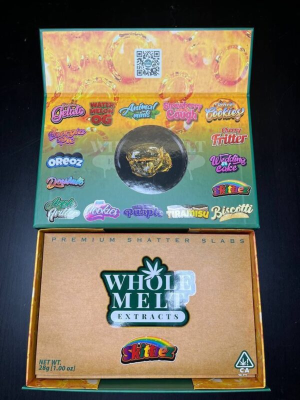 An open cardboard box displays various cannabis product names with vibrant logos such as "Animal Mints" and "Cherry Fritter" on the inside of the lid. The bottom section shows a brown package labeled "Whole Melt Skittlez" and "Premium Shatter Slabs.